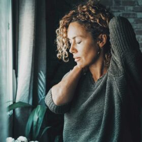 woman with radiating neck pain holder her neck and shoulder